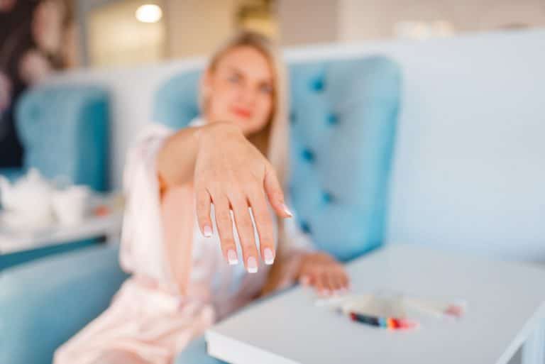 Customer shows perfectly made nails in beauty shop
